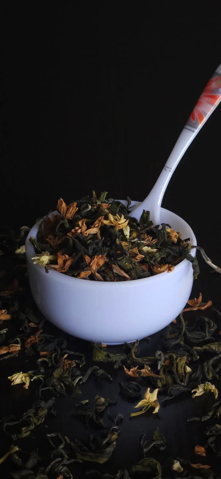 Loose whole-leaf jasmine tea in a white tasting bowl